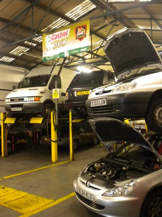 Cars on vehicle lifts inside the garage